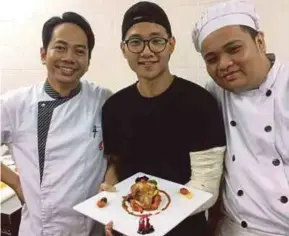  ??  ?? Goh Kah How (centre) is all smiles showing his food art, Circle of Red Ocean.