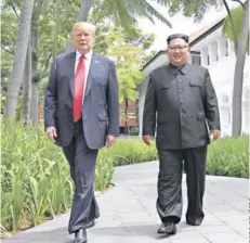  ??  ?? ► Trump y Kim caminan durante una pausa en sus conversaci­ones en el Hotel Capella, en Singapur.