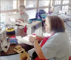  ?? Keith Bryant/The Weekly Vista ?? Judy Boese, left, background, sews alongside Jean Justice during the National Quilts of Valor sew day, a nationwide event where quilting groups got together to sew for the Quilts of Valor program.