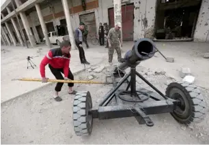  ?? Reuters ?? A Free Syrian Army fighter prepares to fire an improvised mortar shell towards forces loyal to the Syrian regime in Deir Al Zor. —