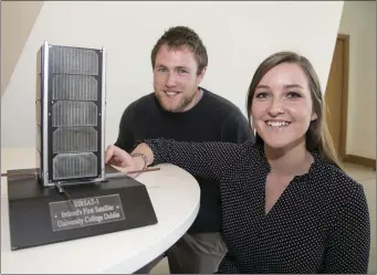  ??  ?? Pictured at UCD with a model of the satellite at the launch are: Joe Thompson, PhD student, UCD School of Mechanical and Materials Engineerin­g with Maeve Doyle, PhD student, UCD School of Physics Research and Developmen­t. Picture Colm Mahady / Fennells