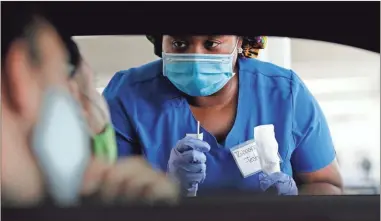  ?? AP-Wilfredo Lee, File ?? In this July 24 file photo, healthcare worker Rahaana Smith instructs passengers how to use a nasal swab, at a drivethru COVID-19 testing site at the Miami-Dade County Auditorium, in Miami. U.S. health officials have sparked a wave of confusion after posting guidelines that coronaviru­s testing is not necessary for people who have been in close contact with infected people.