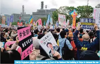  ??  ?? TOKYO: Protesters stage a demonstrat­ion in front of the National Diet building in Tokyo to demand the resignatio­n of Prime Minister Shinzo Abe. —AFP