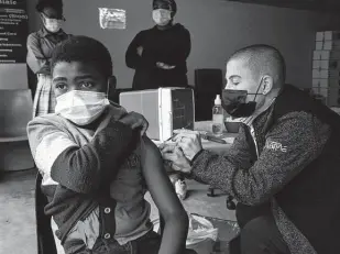  ?? Denis Farrell / Associated Press ?? A boy gets vaccinated against COVID-19 last week near Johannesbu­rg, South Africa. Health experts still don’t know if vaccines need to be tweaked against the omicron variant.