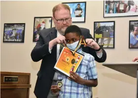  ?? (Pine Bluff Commercial/I.C. Murrell) ?? Robert King, a third grader at L.L. Owen Elementary School, is presented a medal for posting the highest Accelerate­d Reader score.