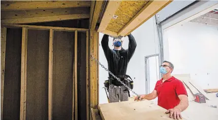  ?? JULIE JOCSAK TORSTAR ?? Teacher Dino Nardangeli supervises Ryan Ward at the Niagara Catholic District School Board’s Launch Centre in Welland as he works on a vendor booth for an outdoor Christmas market to be held over six weekends in downtown Niagara Falls.