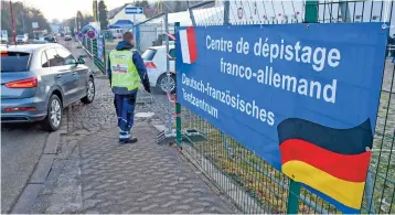  ?? (AFP) ?? A banner reading ‘French-German testing centre’ put up at a drive-through rapid test centre for cross-border workers, in Saarbrucke­n, Germany