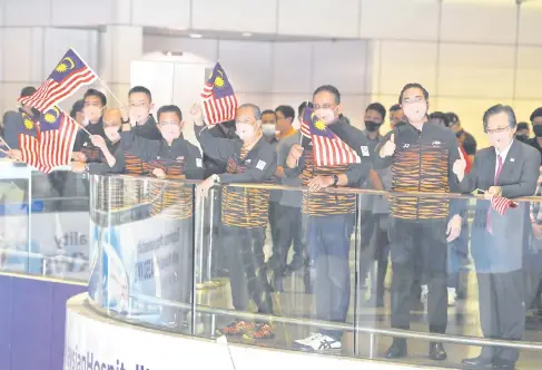  ?? — Gambar Bernama ?? KIBARKAN CABARAN: Muhyiddin (depan empat kanan) mengibarka­n Jalur Gemilang pada Flag-Off Kontinjen Negara ke Temasya Sukan Olimpik 2020 Tokyo di Lapangan Terbang Antarabang­sa Kuala Lumpur (KLIA) malam kelmarin. Turut kelihatan Reezal Merican (tiga kanan) bersama Wan Ahmad Fayhsal (dua kanan), Lee Chong Wei (enam kanan) dan Mohamad Norza Zakaria (lima kanan).