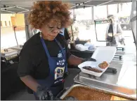  ?? ?? Donna Crockett of Luv’n & Crockett’s Homestyle BBQ serves a plate for a customer during the festival.