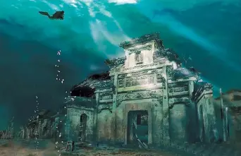  ??  ?? Two ancient cities lie in an eerie graveyard under the waters of Qiandao Lake. Diving and underwater tourism have been banned to help preserve the structures.
