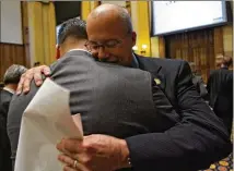  ??  ?? In 2007, Georgia Senate President Pro Tempore Eric Johnson (facing) hugged state Rep. David Casas after Casas informed him the House had just passed his special-needs school voucher bill.