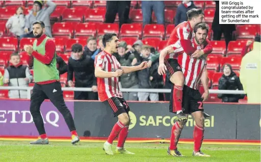  ??  ?? Will Grigg is congratula­ted by team-mates after getting off the mark for Sunderland