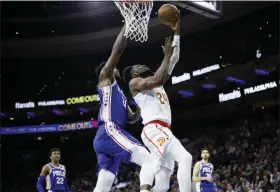  ?? THE ASSOCIATED PRESS ?? Atlanta Hawks’ Bruno Fernando (24) goes up to shoot against Philadelph­ia 76ers’ Joel Embiid (21) during the first half of an NBA basketball game, Monday.