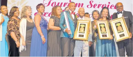  ??  ?? Tourism Minister Edmund Bartlett (right) poses with Conroy Thompson (centre), training manager at Half Moon Hotel in Montego Bay, and other members of the Half Moon team as they showcase their national and regional awards.