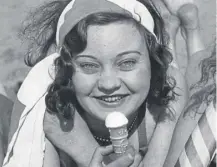  ?? ?? ↑ A young women enjoys an ice-cream cornet, introduced to the UK today in 1912, on the beach in 1939