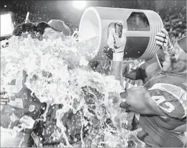  ?? Robert Gauthier Los Angeles Times ?? UCHENNA NWOSU douses coach Clay Helton with a Gatorade bucket bath following the Trojans’ 28-23 win over UCLA at the Coliseum on Saturday.