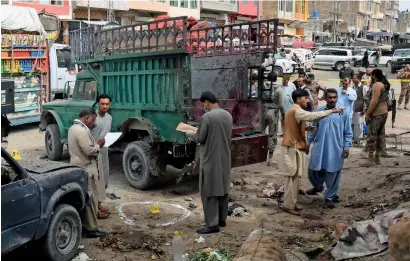  ?? — AFP ?? Pakistani security officials inspect the site of a bomb blast at a fruit market in Quetta on Friday.