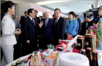  ?? WANG ZHUANGFEI / CHINA DAILY ?? Wang Guosheng (second from left), Party chief of Henan province, introduces some of the goods imported and exported by the province to guests including Wang Yi, China’s foreign minister, and Terry Branstad, ambassador of the United States to China,...
