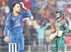  ??  ?? Rashid Khan (left) gestures as he dismisses Bangladesh cricketer Mushfiquri­m Rahim during the final day of Twenty20 Internatio­nal cricket match between Afghanista­n and Bangladesh at Rajiv Ghandi Internatio­nal Cricket Stadium in Dehradun. — AFP photo