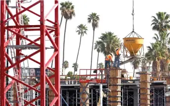  ?? — AFP photos ?? Constructi­on workers help build a mixed-use apartment complex in Los Angeles, California.