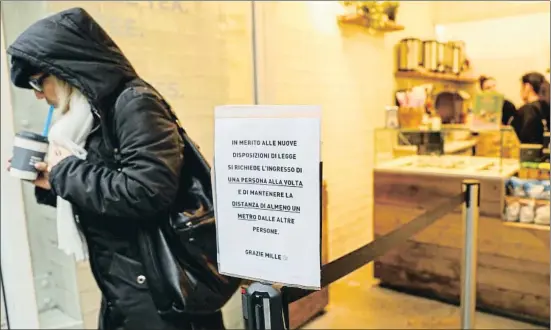  ?? GUGLIELMO MANGIAPANE / REUTERS ?? Una nota en la entrada de una pastelería advierte a los clientes que entren de uno en uno y mantengan una distancia de un metro entre sí, en Milán