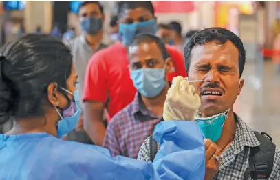  ?? Picture: AFP ?? Passengers queue up for Covid-19 screening after arriving at a railway station in Mumbai yesterday.