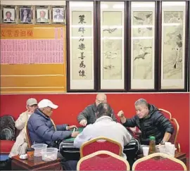  ?? Luis Sinco Los Angeles Times ?? A GROUP of men play mah-jongg at the Hop Sing Tong a day after two men were fatally stabbed at the Chinatown social club. The assailant is still at large.