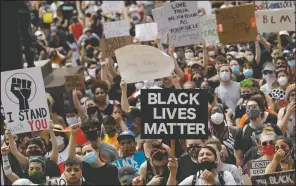  ??  ?? People hold signs as they listen to a speaker in front of city hall in downtown Kansas City, Mo., during a June 5 rally to protest the death of George Floyd.
(AP/Charlie Riedel)