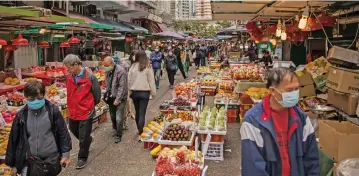  ?? (AFP) ?? People shop at a fresh food market in Hong Kong on Sunday