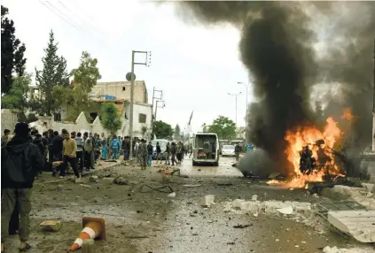  ?? / AZAZ MEDIA OFFICE VIA AP ?? EXPLOSION. This authentica­ted photo provided by Azaz Media Office, a Syrian antigovern­ment activist group, shows Syrian citizens and civil defense workers gathering next of burning car at the explosion scene, in Azaz town, north Syria. Syrian activists...