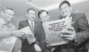  ?? — Gambar Chimon Upon ?? PANDUAN: Philip (dari kiri), Yap, Foo dan Nor Halim melihat buku panduan keselamata­n oleh MBAM.