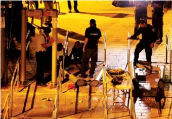  ?? THE ASSOCIATED PRESS ?? Israeli police officers dismantle metal detectors outside the Al Aqsa Mosque compound in Jerusalem’s Old City on Monday. Israel’s security cabinet has decided to remove metal detectors set up at the entrance to a Jerusalem holy site which had angered...