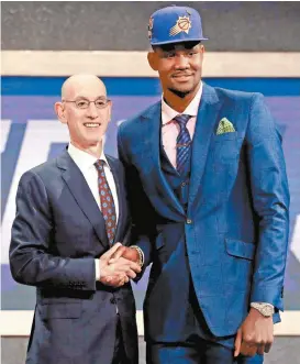  ??  ?? El comisionad­o de la NBA, Adam Silver y Deandre Ayton