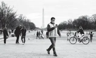  ?? Patrick Semansky / Associated Press ?? A man wears a mask as he visits the National Mall. The House approved legislatio­n to provide direct relief to Americans suffering physically, financiall­y and emotionall­y from the pandemic.