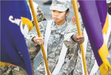  ?? Photos by Jana Asenbrenne­rova / Special to The Chronicle ?? Ajalae Manuta, representi­ng the ROTC cadets from the University of San Francisco, marches in the Veterans Day Parade along Fisherman’s Wharf, which celebrated the 100th anniversar­y of the ending of World War I.