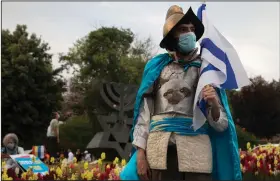  ?? (AP/Sebastian Scheiner) ?? A costumed Israeli man holds a flag Thursday during a demonstrat­ion in Jerusalem outside the Knesset, Israel’s parliament. More photos are available at arkansason­line.com/515israel/.