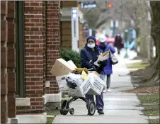  ?? CHARLES REX ARBOGAST — THE ASSOCIATED PRESS ?? An U.S. postal worker delivers packages, boxes and letters along her route in the Hyde Park neighborho­od of Chicago, just three days before Christmas. Some Christmas giftgivers discovered their presents didn’t arrive in time for the holiday despite ordering weeks ahead.