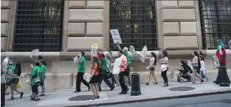  ?? DREW ANGERER/ GETTY IMAGES ?? Low-wage workers and their supporters march around the New York Federal Reserve during a rally last month. Wage increases have been in the doldrums despite a red-hot job market.
