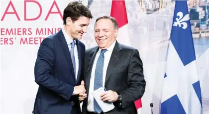  ?? MARTIN OUELLET-DIOTTE ?? Prime Minister Justin Trudeau shakes hands with a jubilant Premier François Legault at the first ministers meeting Friday.