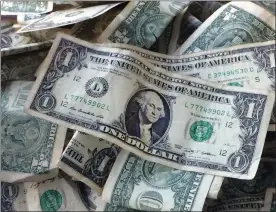  ?? MARK LENNIHAN — ASSOCIATED PRESS FILE ?? An Oct. 24, 2016, file photo shows dollar bills in New York.