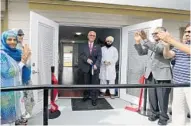  ?? RICARDO RAMIREZ BUXEDA/STAFF PHOTOGRAPH­ER ?? Longwood commission­er John Maingot, accompanie­d by Imam Mufti Mahad, cuts the ceremonial ribbon Friday at the grand opening of the American Muslim Community Clinic in Longwood.