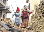  ?? WALLY SANTANA / AP ?? Jagot Kumari Rana, 79, walks through the rubble of Paslang village with grandson Sogat Rana, 7. The hamlet was near the epicenter of the quake.