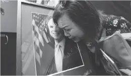  ?? NHAC NGUYEN / AFP / GETTY IMAGES ?? Mai Tran, an American of Vietnamese descent, grieves over a portrait of John Mccain during a memorial tribute at the US Embassy in Hanoi on Monday.