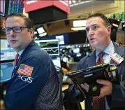  ?? MARK LENNIHAN / ASSOCIATED PRESS ?? Traders work the floor at the New York Stock Exchange on Wednesday. It was another quiet, post-holiday day for the markets, though a couple of economic reports helped drive some trades.