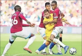  ?? AFP ?? ■ Chelsea's Eden Hazard (centre) vies for the ball with West Ham players on Sunday.