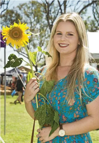  ??  ?? SUNNY DISPOSITIO­N: Carissa Janetzki from Toowoomba enjoys the sunshine, sunflowers and flavours at the Felton Food Festival. PHOTOS: NEV MADSEN