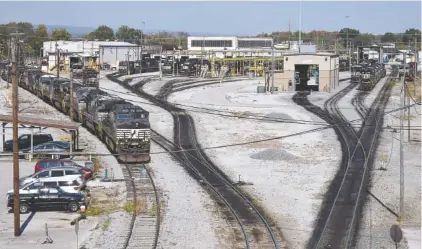  ?? STAFF PHOTO BY ROBIN RUDD ?? Stored locomotive­s rest on the tracks, at left, as other diesels sit on the servicing tracks in front of the diesel shops at Norfolk Southern’s DeButts Yard on Tuesday. Norfolk Southern furloughed 58 workers there Tuesday.