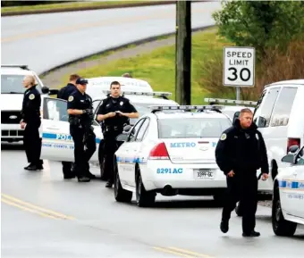  ?? THE ASSOCIATED PRESS ?? Nashville police gather alongside a wooded area Sunday as they search for a shooting suspect near a Waffle House restaurant. Four people died after a gunman opened fire at the restaurant early Sunday.