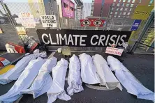  ?? ANDREW MILLIGAN/VIA ASSOCIATED PRESS ?? Climate activists dressed as shrouded bodies protest near the venue for the U.N. Climate Summit in Glasgow, Scotland, on Thursday.