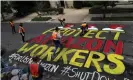  ?? Photograph: ?? Activists paint a sign for the Amazon.com Inc founder Jeff Bezos in Washington on 29 April 2020.